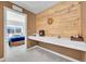 Office with built-in desk and wood accent wall, adjacent to sunlit bedroom at 18284 E 49Th Pl, Denver, CO 80249