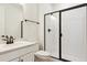 Modern bathroom with glass-enclosed shower, white vanity, and black hardware at 39181 Anthony St, Elizabeth, CO 80107