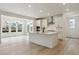 Open kitchen with white cabinets, large island, and stainless steel appliances at 39181 Anthony St, Elizabeth, CO 80107