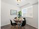 Cozy dining area features a round table, four chairs and natural light from a window at 7700 W Glasgow Place # 15A, Littleton, CO 80128