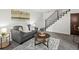 Comfortable living room featuring a gray sofa, stylish coffee table, and staircase with black metal railing at 7700 W Glasgow Place # 15A, Littleton, CO 80128