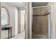 Hallway view of a bathroom featuring a glass shower enclosure with neutral tiling and a modern shower head at 8100 E Union Ave # 712, Denver, CO 80237