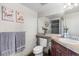 Neutral-toned bathroom with a cherry vanity, granite countertop, decorative floral art, and a modern toilet at 8100 E Union Ave # 712, Denver, CO 80237