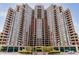 Stunning exterior view of the high-rise building with a beautifully landscaped entrance and surrounding greenery at 8100 E Union Ave # 712, Denver, CO 80237
