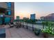 Relaxing outdoor patio with city views at sunset, featuring comfortable seating and potted flowers at 8100 E Union Ave # 712, Denver, CO 80237