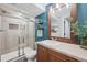 Bathroom with a wood frame mirror, floating shelves, blue accent wall, and glass shower at 11072 Quail Ct, Parker, CO 80134