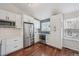 White kitchen boasts stainless steel appliances, sleek cabinetry, herringbone backsplash, and hardwood floors at 11072 Quail Ct, Parker, CO 80134