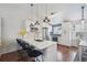 Bright kitchen features white cabinets, quartz countertops, stainless appliances, and bar stool seating at 11072 Quail Ct, Parker, CO 80134