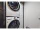 Laundry room area showcasing a stacked washer and dryer, next to a white storage cabinet at 11072 Quail Ct, Parker, CO 80134