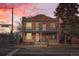 A classic brick two-story house featuring a balcony, green trim, and a well-maintained facade during sunset at 300 S Lincoln St, Denver, CO 80209
