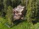 Aerial shot showing the house with a spacious deck and fenced yard, surrounded by lush greenery at 10858 Norton Ave, Conifer, CO 80433
