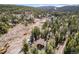 Tranquil aerial shot of wooded community with multiple ponds near a wood home on a large lot at 10858 Norton Ave, Conifer, CO 80433