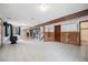Spacious basement featuring a wood-burning stove, workout area, and wood paneled walls at 10858 Norton Ave, Conifer, CO 80433