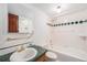 Charming bathroom with green and white tile accents, a vanity, and a tub-shower combination at 10858 Norton Ave, Conifer, CO 80433