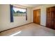 Carpeted bedroom featuring a window with a forest view and a wooden closet and door at 10858 Norton Ave, Conifer, CO 80433