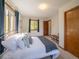 Bedroom features a large window, cozy carpet, bench, and a bed with decorative pillows and blankets at 10858 Norton Ave, Conifer, CO 80433