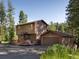 Charming two-story home with a deck and detached garage, surrounded by lush greenery at 10858 Norton Ave, Conifer, CO 80433