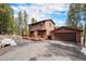 Inviting two-story home with a charming front porch and a detached garage in a wooded setting at 10858 Norton Ave, Conifer, CO 80433