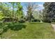 Large grassy backyard with mature trees offering plenty of shade, and a wooden fence at 11328 W 27Th Ave, Lakewood, CO 80215