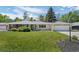 Landscaped front yard showcases mature trees and lush green grass surrounding a single-story residence with an attached garage at 11328 W 27Th Ave, Lakewood, CO 80215