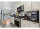Modern kitchen boasts stainless steel appliances, dark countertops, white cabinetry, and hardwood floors in an open layout at 11328 W 27Th Ave, Lakewood, CO 80215