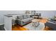 Cozy living room featuring hardwood floors, a comfortable gray sofa, a patterned rug, and views into the dining area at 11328 W 27Th Ave, Lakewood, CO 80215