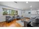 Bright living room with hardwood floors, updated lighting, comfortable seating, and a large window with exterior views at 11328 W 27Th Ave, Lakewood, CO 80215