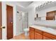 Bright bathroom featuring a step-in shower, wooden cabinets, and a large mirror above the sink at 3022 S Wheeling Way # 205, Aurora, CO 80014