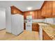 Efficient kitchen with white appliances, wood cabinets, light countertops, and a wood-look floor at 3022 S Wheeling Way # 205, Aurora, CO 80014