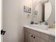 Modern half bathroom features a stylish vanity and a round mirror at 2695 W Grand Ave, Littleton, CO 80123