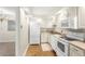Efficient kitchen featuring white appliances, neutral counters, hardwood floor, and white cabinets at 3082 S Wheeling Way # 106, Aurora, CO 80014