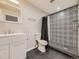 Basement bathroom with white vanity, patterned shower, and black floor at 846 S Sheridan Blvd, Denver, CO 80226