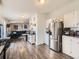 Open-concept kitchen featuring white cabinets, stainless steel appliances, and a breakfast bar at 846 S Sheridan Blvd, Denver, CO 80226