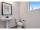 Compact powder room featuring a pedestal sink, toilet, and modern lighting at 6882 Oak Canyon Cir, Castle Pines, CO 80108