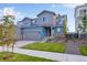 Townhome with two-car garage, stone accents, professional landscaping and a green lawn at 6882 Oak Canyon Cir, Castle Pines, CO 80108