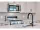 Close up of the kitchen features stainless steel microwave, stove and a modern faucet at 6882 Oak Canyon Cir, Castle Pines, CO 80108