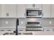 Close up of stainless steel microwave and stove with quartz countertops and a sleek design at 6882 Oak Canyon Cir, Castle Pines, CO 80108