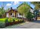 Well-manicured front yard featuring a charming white home with black trim and a rustic wooden porch at 1801 Redwood Ave, Boulder, CO 80304