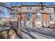 Tan and brick townhouse exterior with attached garage and landscaping at 3300 W Florida Ave # 77, Denver, CO 80219