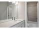Modern bathroom featuring a single sink vanity, large mirror, and a shower with gray tile surround at 7040 Homeplace St, Castle Rock, CO 80108