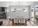 Modern dining room with fireplace, rustic wood table, upholstered chairs, and elegant chandelier at 7040 Homeplace St, Castle Rock, CO 80108