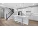 Modern kitchen with white cabinetry, stainless steel appliances, an island with barstool seating, and hardwood floors at 7040 Homeplace St, Castle Rock, CO 80108