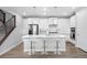 Bright kitchen with white cabinets, stainless appliances, an island with barstool seating, and hardwood floors at 7040 Homeplace St, Castle Rock, CO 80108