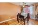 Cozy dining area with a table set for four, illuminated by a ceiling fan and natural light at 3035 S Biscay St, Aurora, CO 80013