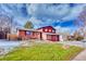 Beautiful home with well-manicured lawn, lush grass, and mature trees on a sunny, partly cloudy day at 3035 S Biscay St, Aurora, CO 80013