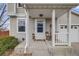 Inviting front porch with a charming white door, flower decoration, and a welcome mat at 1495 Hummingbird Cir, Brighton, CO 80601