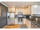 Modern kitchen with stainless steel appliances and light wood cabinetry at 1495 Hummingbird Cir, Brighton, CO 80601