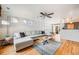 Spacious living room with a gray sectional sofa, hardwood floors, and lots of natural light at 1495 Hummingbird Cir, Brighton, CO 80601