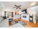 Open-concept living room featuring hardwood floors, a modern fireplace, and comfortable seating at 1495 Hummingbird Cir, Brighton, CO 80601