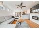 Open-concept living room with a gray sectional sofa, hardwood floors, and view into dining area at 1495 Hummingbird Cir, Brighton, CO 80601